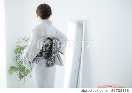 A woman who wears a kimono by herself A woman who wears a kimono by herself 83788118