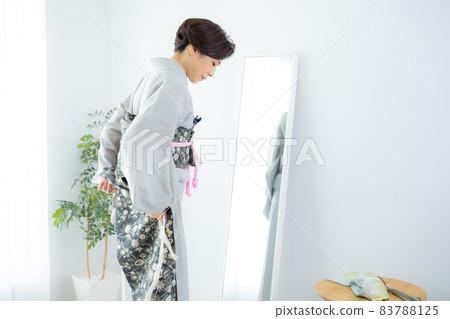 A woman who wears a kimono by herself A woman who wears a kimono by herself 83788125