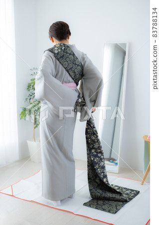 A woman who wears a kimono by herself A woman who wears a kimono by herself 83788134
