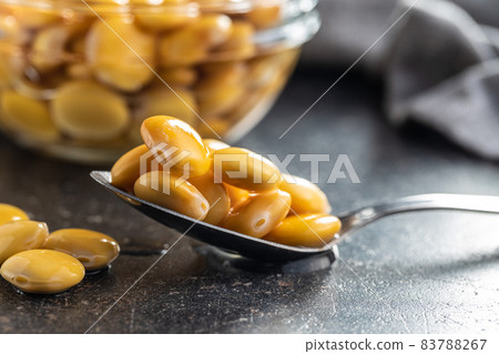 Pickled yellow Lupin Beans in spoon. Pickled yellow Lupin Beans in spoon. 83788267