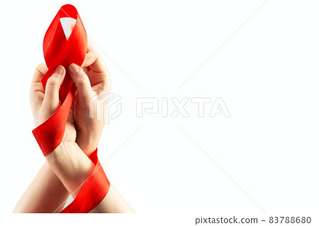 Health care and medicine concept. AIDS awareness. Two female hands are tied with a red AIDS awareness ribbon on a white background. International AIDS Day 83788680