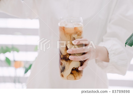Woman's hand pouring milk to make caffe latte Woman's hand pouring milk to make caffe latte 83789898