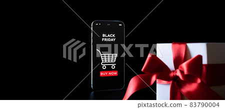 Online shopping gifts. Black Friday banner with internet shopping app on mobile phone, white gifts with red bow falling on black background. Present online concept. Online shopping gifts. Black Friday banner with internet shopping app on mobile phone, white gifts with red bow falling on black background. Present online concept. 83790004