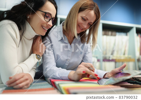 Woman designer choosing fabric sample for curtains in workshop 83790032