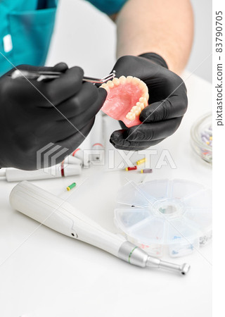 Orthodontist is working on cast of jaw. Orthodontics. Orthodontist makes a denture. 83790705