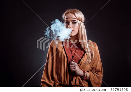 Young woman in the Boho style blowing smoke 83791298