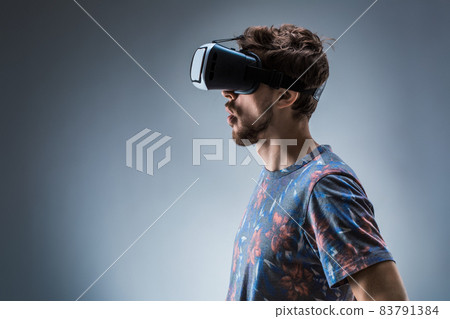 Side view of a young guy using a VR headset. Emotions Side view of a young guy using a VR headset. Emotions 83791384