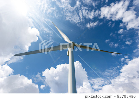 Wind Turbine against a Blue sky with Clouds and Sun Rays - Renewable Energy 83793486