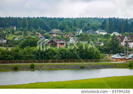 View from a height of cottages by the river. A view from above on a panorama of cottages by the river. Mountain landscape View from a height of cottages by the river. A view from above on a panorama of cottages by the river. Mountain landscape 83794288