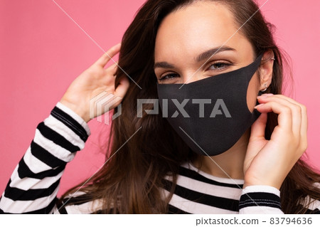 Shot of young attractive woman wearing mediacal face mask isolated over background wall. Protection Shot of young attractive woman wearing mediacal face mask isolated over background wall. Protection 83794636
