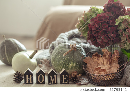 Autumn still life of pumpkins, autumn leaves and hydrangea flowers on a blurred background. The concept of autumn comfort at home. Autumn still life of pumpkins, autumn leaves and hydrangea flowers on a blurred background. The concept of autumn comfort at home. 83795141