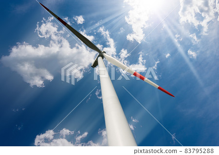 Wind Turbine against a Blue sky with Clouds and Sun Rays - Renewable Energy Wind Turbine against a Blue sky with Clouds and Sun Rays - Renewable Energy 83795288