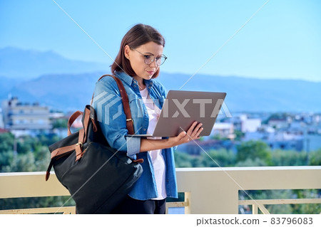 Confident serious mature business woman with laptop outdoors. Confident serious mature business woman with laptop outdoors. 83796083