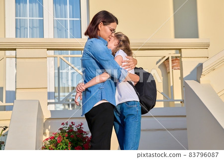 Mom and her daughter, a schoolgirl, are on the doorstep Mom and her daughter, a schoolgirl, are on the doorstep 83796087