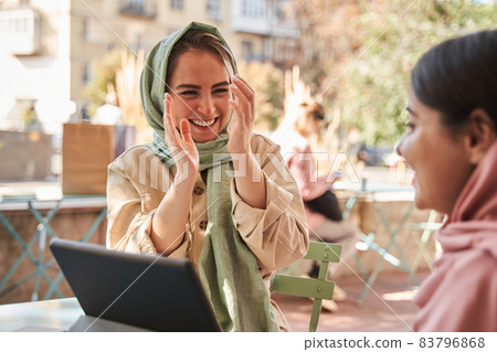 Female laughing out loud while spending time with her best friend at the street 83796868