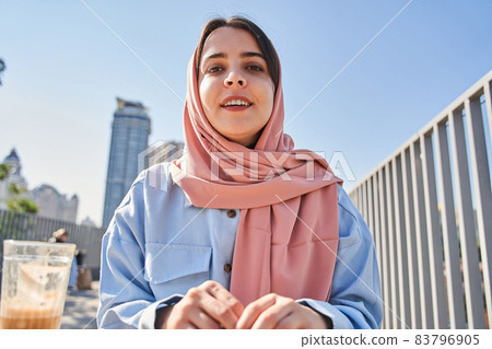 Multiracial blogger woman wearing head scarf broadcasting at the street Multiracial blogger woman wearing head scarf broadcasting at the street 83796905