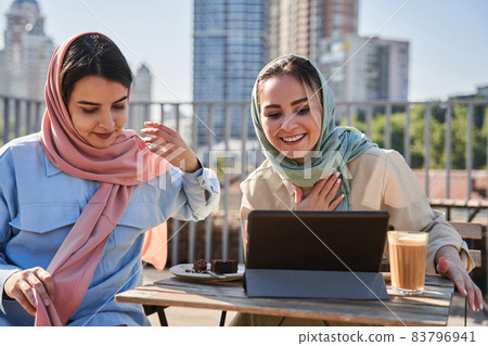 Islamic sisters chatting with their relatives via video call at the tablet computer 83796941