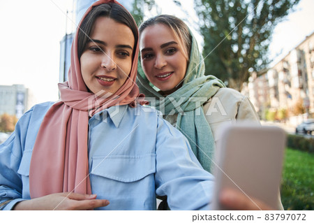 Muslim girls bonding to each other and taking picture together at the modern smartphone 83797072