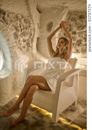 A woman sitting in a salt room and looking relaxed A woman sitting in a salt room and looking relaxed 83797374
