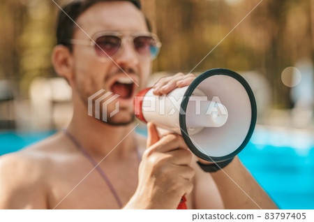 Male lifeguard warning visitors about emergency situation Male lifeguard warning visitors about emergency situation 83797405