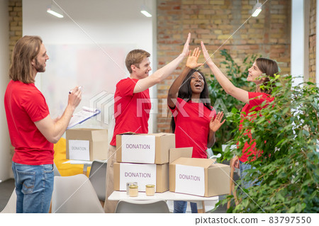 Young volunteers in red tshirts at work in a distribution point Young volunteers in red tshirts at work in a distribution point 83797550
