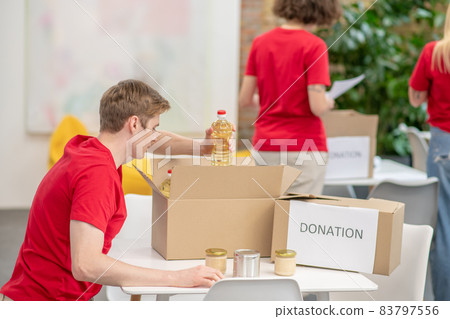 A group of young volunteers at work in a distribution point A group of young volunteers at work in a distribution point 83797556