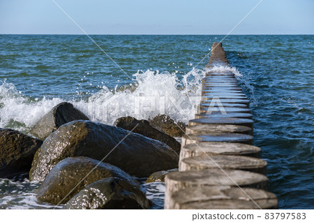 Waves crashing on breakwaters. Sea wave splashing. Waves and a storm at sea. Baltic Sea. 83797583
