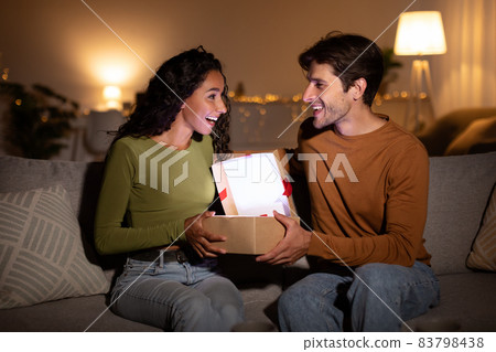 Husband Giving Christmas Gift To Wife, Opening Box Together Indoor Husband Giving Christmas Gift To Wife, Opening Box Together Indoor 83798438