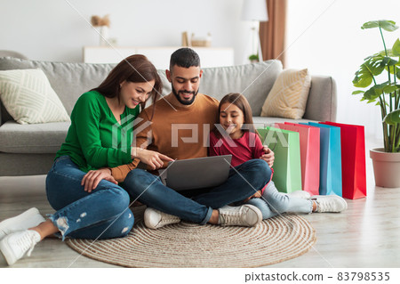 Happy Arab family using laptop in living room Happy Arab family using laptop in living room 83798535