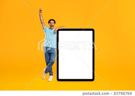 Yes. Man leaning on blank empty tablet screen celebrating success Yes. Man leaning on blank empty tablet screen celebrating success 83798769