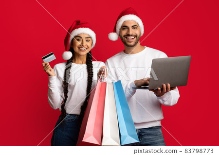 Holiday Shopping Online. Cheerful arab couple posing with laptop and credit card 83798773