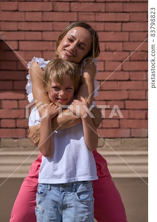 Mother and two kids walking in city center. 83798823