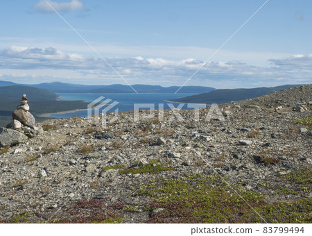 View on Tjaktjajaure lake, valley from Kungsleden hiking trail in Sarek national park, Sweden Lapland. Nordic wild landscape with mountains, hill, rocks and birch trees. Summer sunny day, blue sky View on Tjaktjajaure lake, valley from Kungsleden hiking trail in Sarek national park, Sweden Lapland. Nordic wild landscape with mountains, hill, rocks and birch trees. Summer sunny day, blue sky 83799494