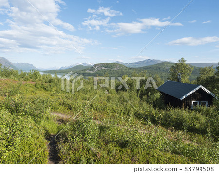 Mountain lodge on the shore of lake Lulealven, Lule river dam in Saltoluokta in birch forest in Sweden Lapland. Summer cabin on famous Kungsleden, Kings hiking trail 83799508