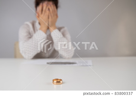 Widow mourns the death of her husband. Caucasian woman signs divorce papers and cries 83800337