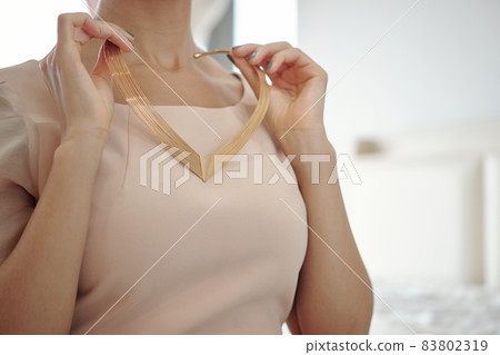 Woman Taking On Beautiful Necklace 83802319