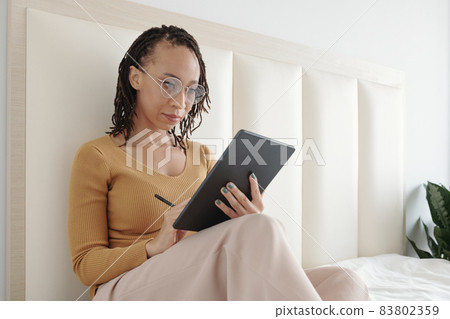 Woman Correcting Document on Tablet 83802359