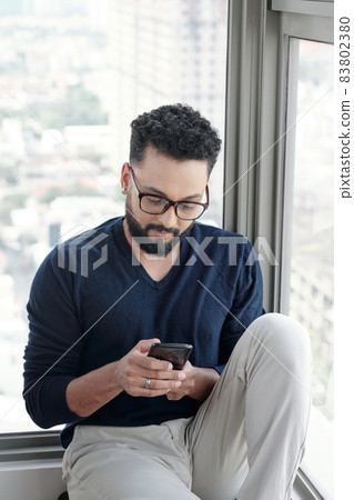 Serious Man Answering Text Messages 83802380