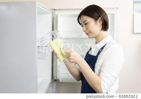 Woman housekeeper cleaning the fridge Woman housekeeper cleaning the fridge 83802921