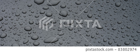 Raindrops on glass against background of dark sky closeup Raindrops on glass against background of dark sky closeup 83802974