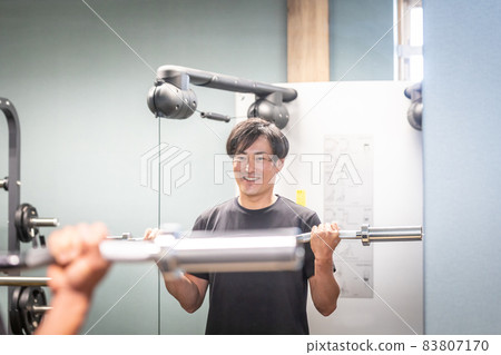 一個男人用槓鈴桿檢查表格(微笑) 一個男人用槓鈴桿檢查表格(微笑) 83807170