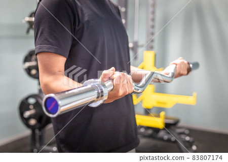Male checking form on barbell shaft (no face) Male checking form on barbell shaft (no face) 83807174