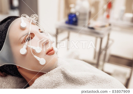 Woman receiving facial massage in beauty salon. Woman receiving facial massage in beauty salon. 83807909