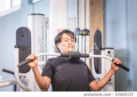 一個男人在健身房使用拉力機 一個男人在健身房使用拉力機 83808135