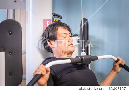 一個男人在健身房使用拉力機 一個男人在健身房使用拉力機 83808137