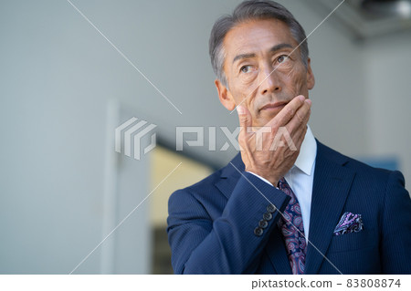 Middle-aged businessman changing into a suit in the living room Middle-aged businessman changing into a suit in the living room 83808874