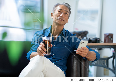 中間人在客廳裡看智能手機 83808903