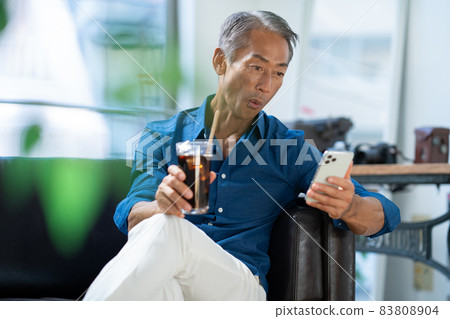 中間人在客廳裡看智能手機 中間人在客廳裡看智能手機 83808904