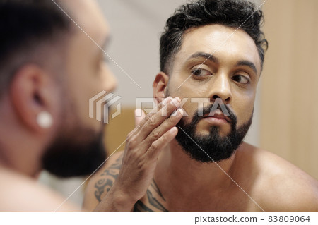 Handsome Man Applying Face Lotion 83809064