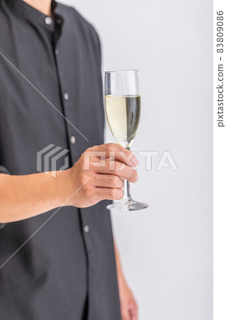 A man standing with a glass of champagne A man standing with a glass of champagne 83809086